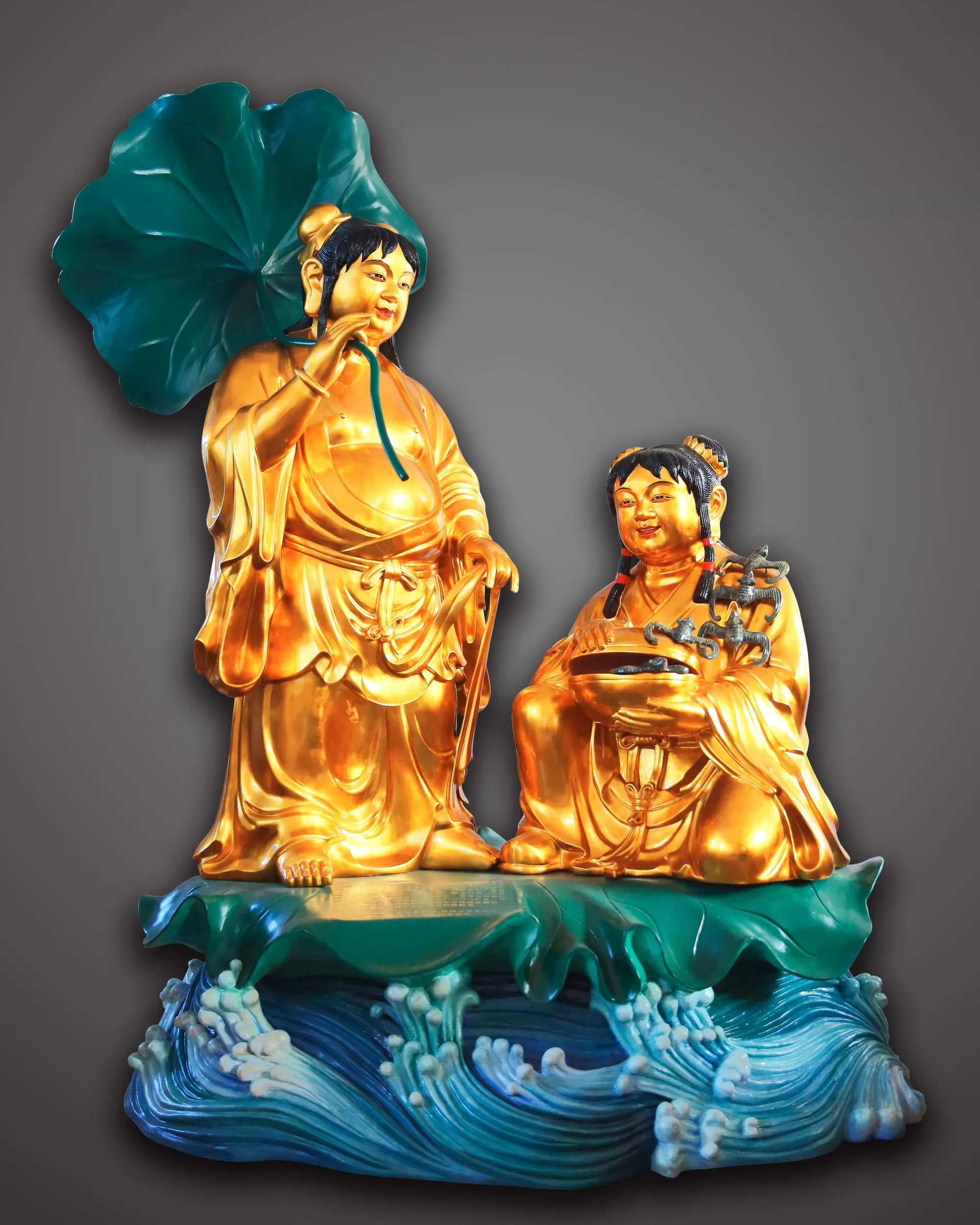 The Immortals of Harmony beneath a large green lotus leaf, on blue waves.