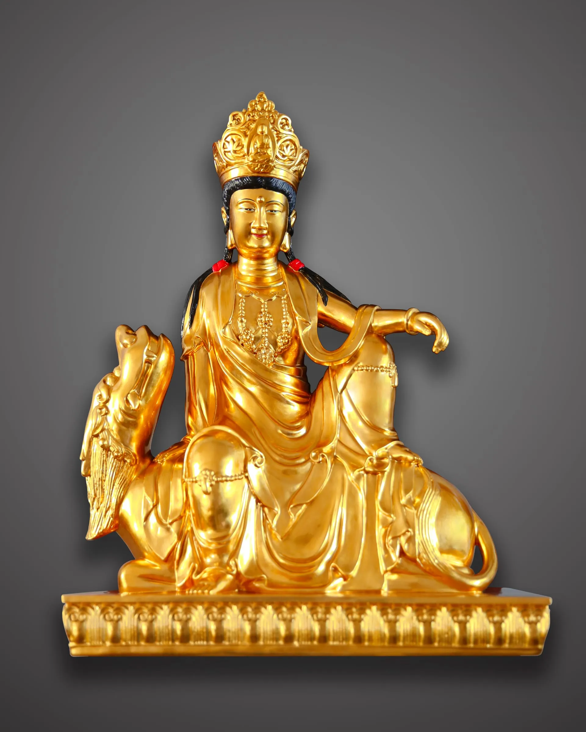 Gilded Guanyin seated on a recumbent lion.
