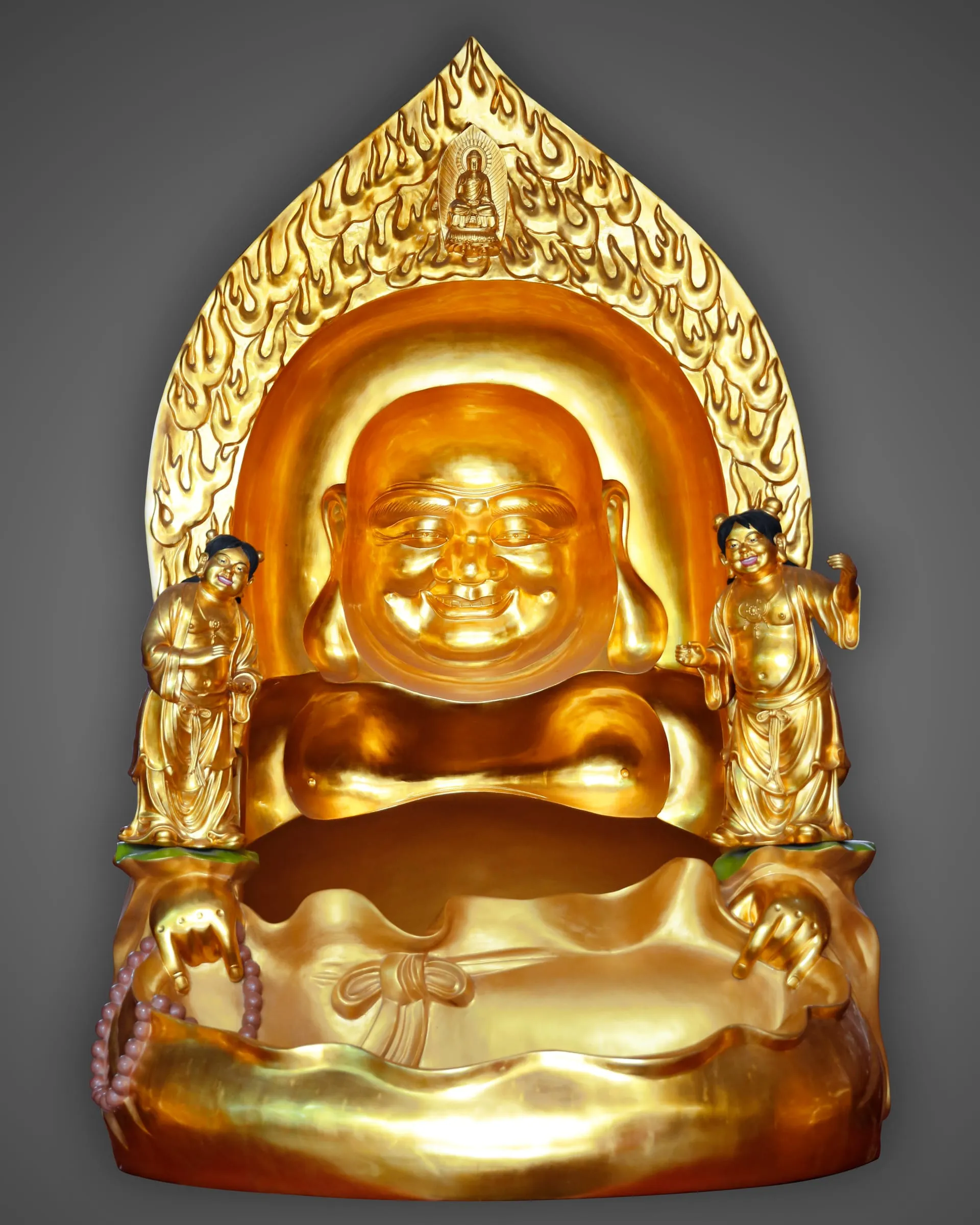 Gilded laughing Maitreya seated before a tall flame-patterned mandorla.